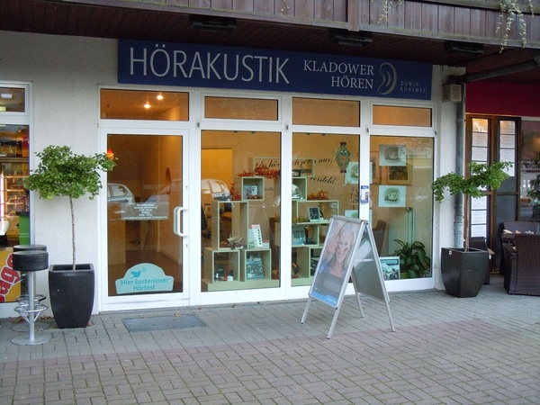 Das Bild zeigt das Geschäft Hörakustik Kladow mit Schaufenster und Werbetafel für Hörgeräte.